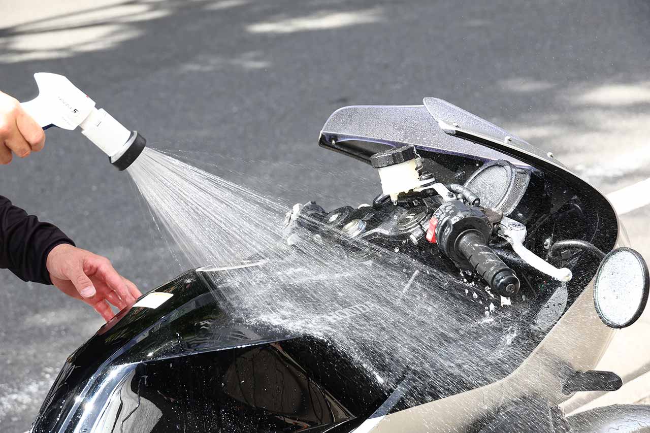 ②バイクの上からシャワーし、汚れを洗い流す。現代のバイクなら、家庭用シャワーの水圧でどうなることはないので、気兼ねなく水をかけて落ちやすい砂や泥などの汚れを流す